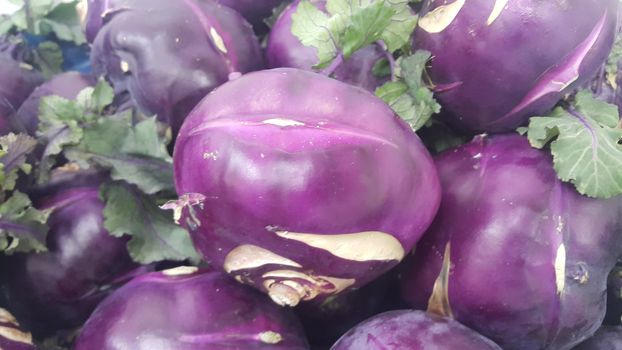 Fruits background: Purple fresh kohlrabi turnip in supermarket for sale.
