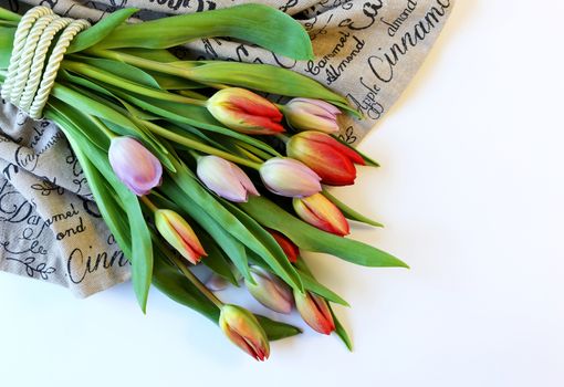 Bunch of fresh spring colorful flowers tulips on canvas white background. Mock up, board, card, banner