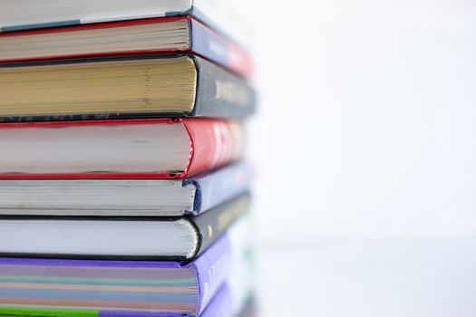 Stacked old books from cover side, soft focus, close up. Learning, reading, adventure of curiosity.