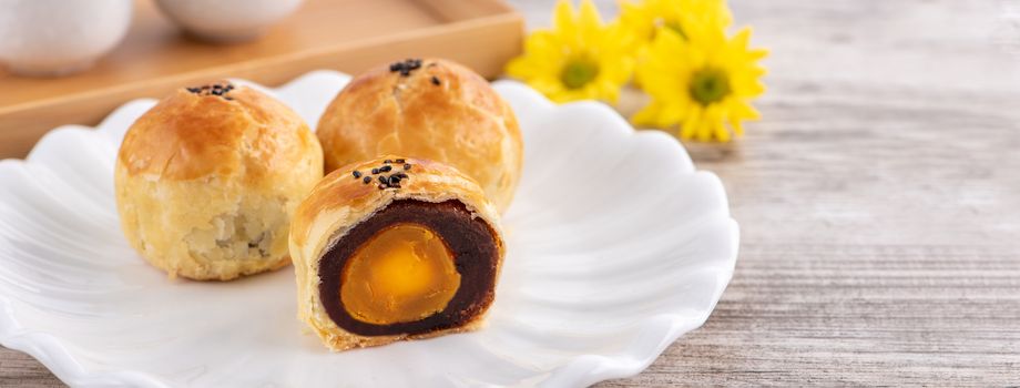 Moon cake yolk pastry, mooncake for Mid-Autumn Festival holiday, top view design concept on bright wooden table with copy space