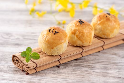 Moon cake yolk pastry, mooncake for Mid-Autumn Festival holiday, top view design concept on bright wooden table with copy space