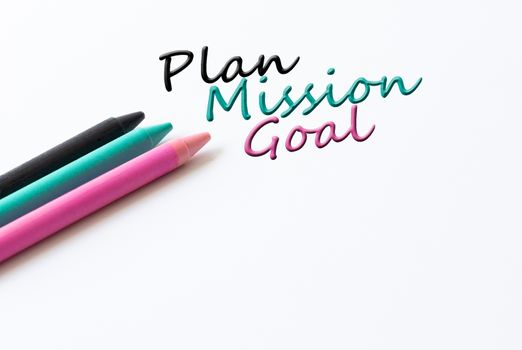 Words Plan, Mission, Goal and colored crayons on white background. Hand writing business process concept.