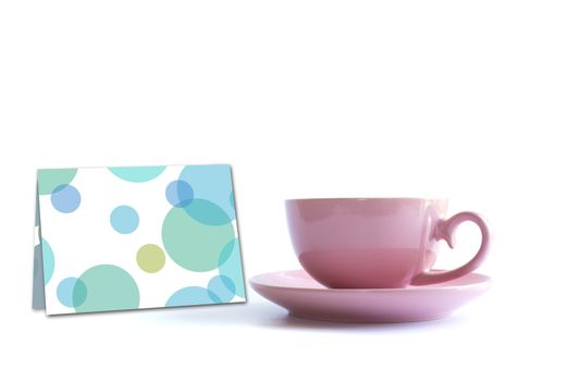 Pink porcelain cup of tea with greeting card on white background. Card, poster, mock up. Celebrating, anniversary, birthday concept.