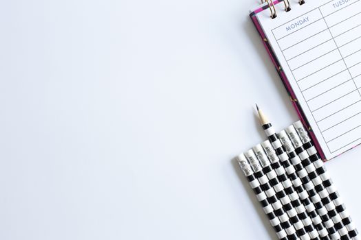 Weekly organizer planner, shaper and sharp pencil surrounded by dull pencils. Stationery flat lay. Back to school. White background. Business, sharp idear concept. Mock up