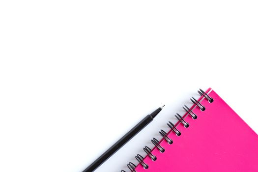Bright pink spiral planner and balck pen. Stationery flat lay. Back to school, home office, things to remember concept. White background