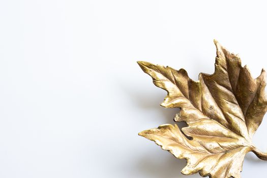 Golden symbol of artificial maple leaf on white background