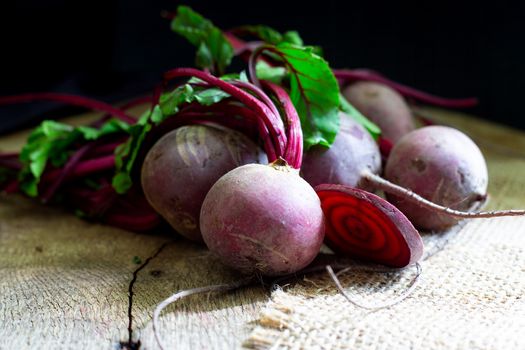 Bunch of fresh, spring, organic beetroot on old wooden background. Horisontal view. Rustic, dramatic, organic kitchen. Soft morning light .Ingredients, menu. Healthy life diet concept