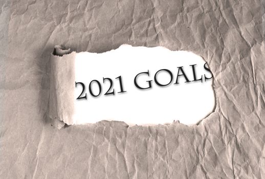 Word 2021 Goals on torn brown grunge paper background. new year 2021 resolution, setting up goals, targets to achieve concept.