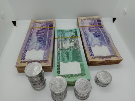 Bangladeshi bank note and coin on white background