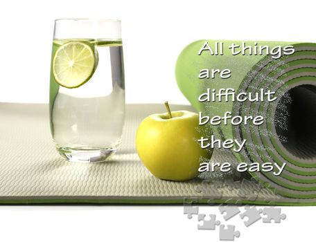 Green yoga mat with apple and glass of water with lemon on white background. Fitness motivation quote All things are difficult before they are easy. Healthy life concept