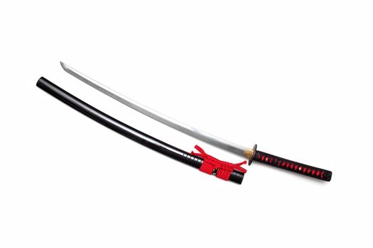 Japanese sword with red cord   steel fitting and shiny black scabbard on white background. Selective focus.