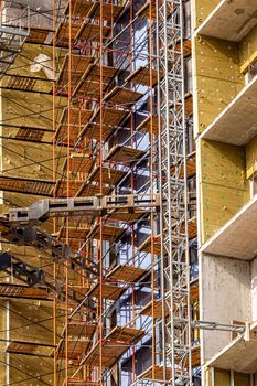 Fragment of an unfinished building under construction with scaffolding.