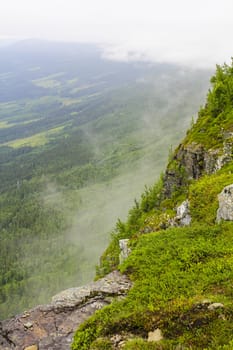 Fog, clouds, rocks and cliffs on Veslehødn Veslehorn mountain in Hemsedal, Norway.