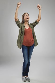 Beautiful and successful young woman with arms raised