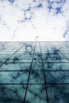 The reflection of the clouds on the glass facade of a building