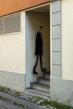 the drawing of a man on a wall as he climbs the steps to enter the house