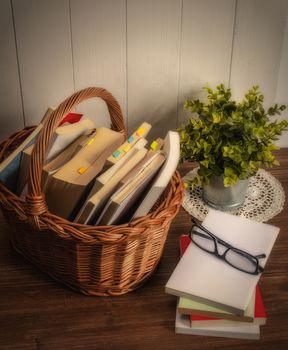 a wicker basket with some books on a wooden table
