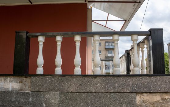 Porch with black railing and white twisted posts. The old porch.