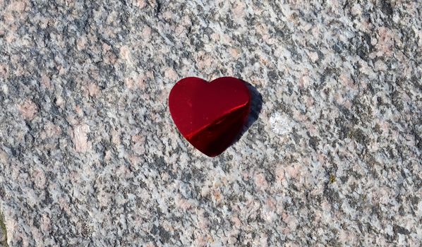 Romantic red love heart lying on a granite background