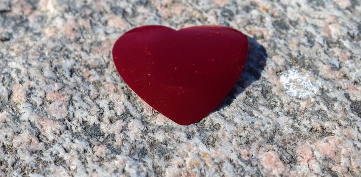 Romantic red love heart lying on a granite background