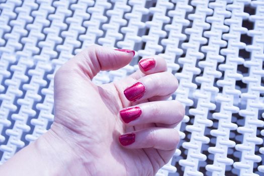 Womans hand with red painted nails. Copy space