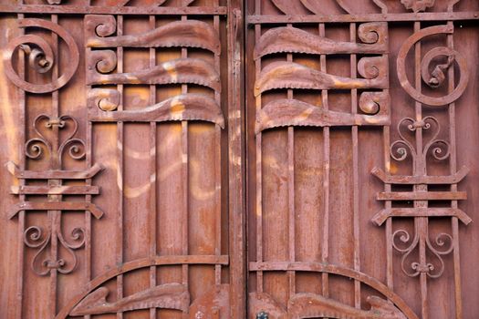 old metal brown gate decorated with forged elements close-up