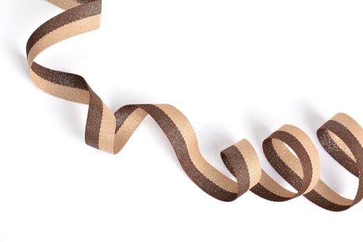 Brown beige Cotton ribbon, roll textilies on bobbin. strapping tape with curl on white backgroud. Use for sewing clothes, bags. Space for text.