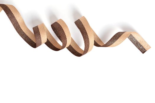 Brown beige Cotton ribbon, roll textilies on bobbin. strapping tape with curl on white backgroud. Use for sewing clothes, bags. Space for text.
