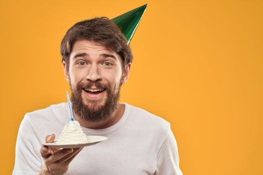 A bearded man with a cake and in a cap celebrating his birthday. High quality photo