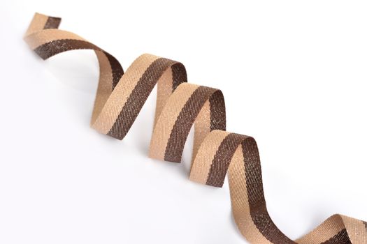 Brown beige Cotton ribbon, roll textilies on bobbin. strapping tape with curl on white backgroud. Use for sewing clothes, bags. Space for text.