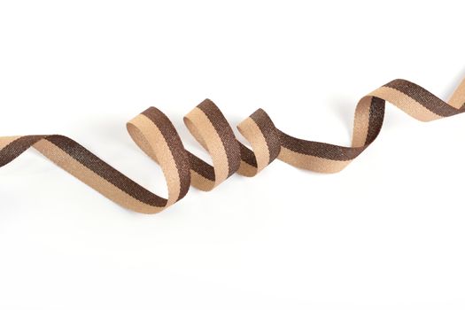 Brown beige Cotton ribbon, roll textilies on bobbin. strapping tape with curl on white backgroud. Use for sewing clothes, bags. Space for text.