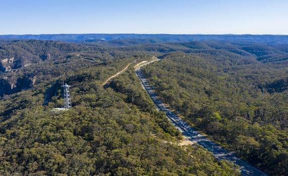 Aerial view of a transmission tower and the Great Western Highway running through forest burnt by bushfires at Mount Victoria in The Blue Mountains in New South Wales in Australia