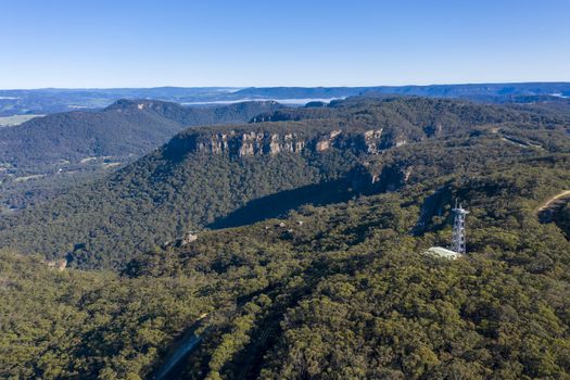 Aerial view of a transmission tower and the Great Western Highway running through forest burnt by bushfires at Mount Victoria in The Blue Mountains in New South Wales in Australia