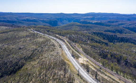 Aerial view of the Great Western Highway running through forest burnt by bushfires at Mount Victoria in The Blue Mountains in New South Wales in Australia