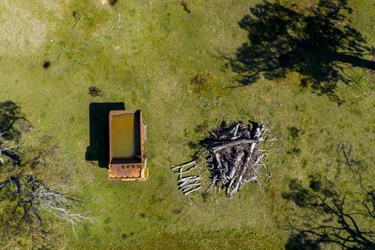 An aerial view of an old earthmoving truck in a lush green agricultural valley in regional Australia