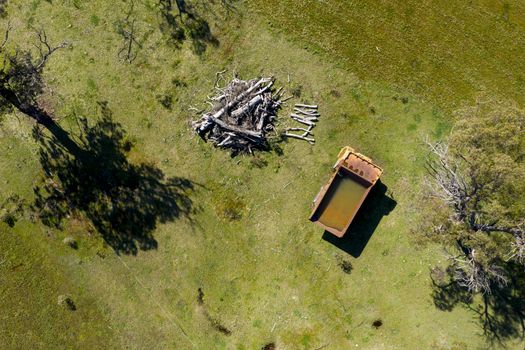 An aerial view of an old earthmoving truck in a lush green agricultural valley in regional Australia