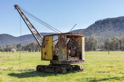 An old rusty crane in a green field in regional Australia