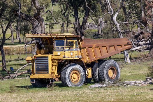 An old rusty earthmoving truck in a green field in regional Australia