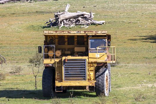 An old rusty earthmoving truck in a green field in regional Australia