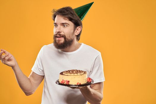 A bearded man with a cake and in a cap celebrating his birthday. High quality photo