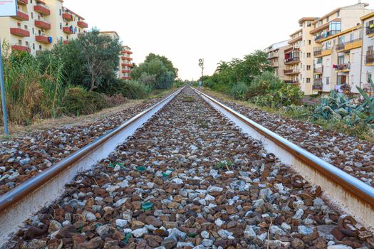 train tracks with sky trees and buildings