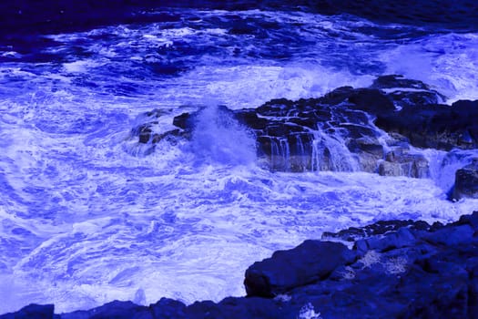 The ocean crashing on rocks with white waves in Kiama New South Wales taken in Infrared