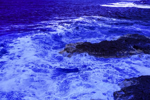 The ocean crashing on rocks with white waves in Kiama New South Wales taken in Infrared