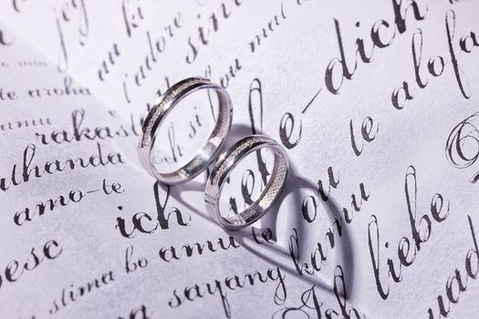 Two wedding rings and shadows on a book