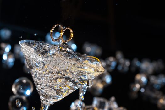 Two engagement rings in the glass on a studio background