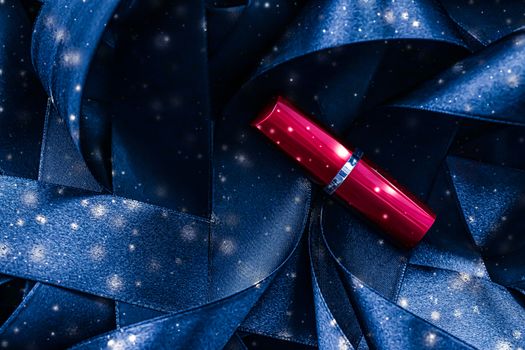 Red lipstick on blue silk and shiny glitter background, luxury make-up and beauty cosmetics