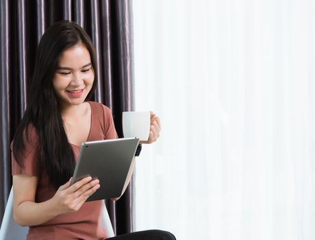 Work from home, Happy Asian young businesswoman smile video conference call or facetime by modern digital smart tablet computer she uses finger touching on screen, looking to tablet at home office