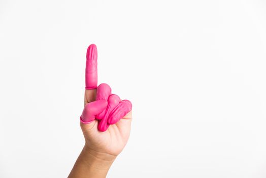 Woman hand wearing pink finger cots rubber protect help prevent fingerprints on the finger touched piece with poinging finger, studio shot isolated on white background