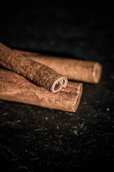 Cinnamon sticks on black stone background, food recipes