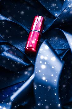 Red lipstick on blue silk and shiny glitter background, luxury make-up and beauty cosmetics